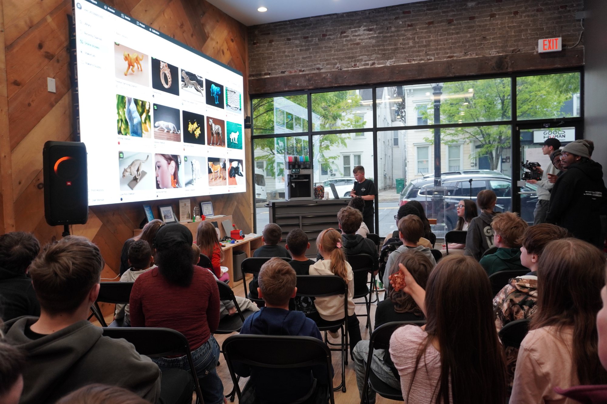 Young people gathered at the JOSHWAY Lab in Easton watching a student present 3D printing designs