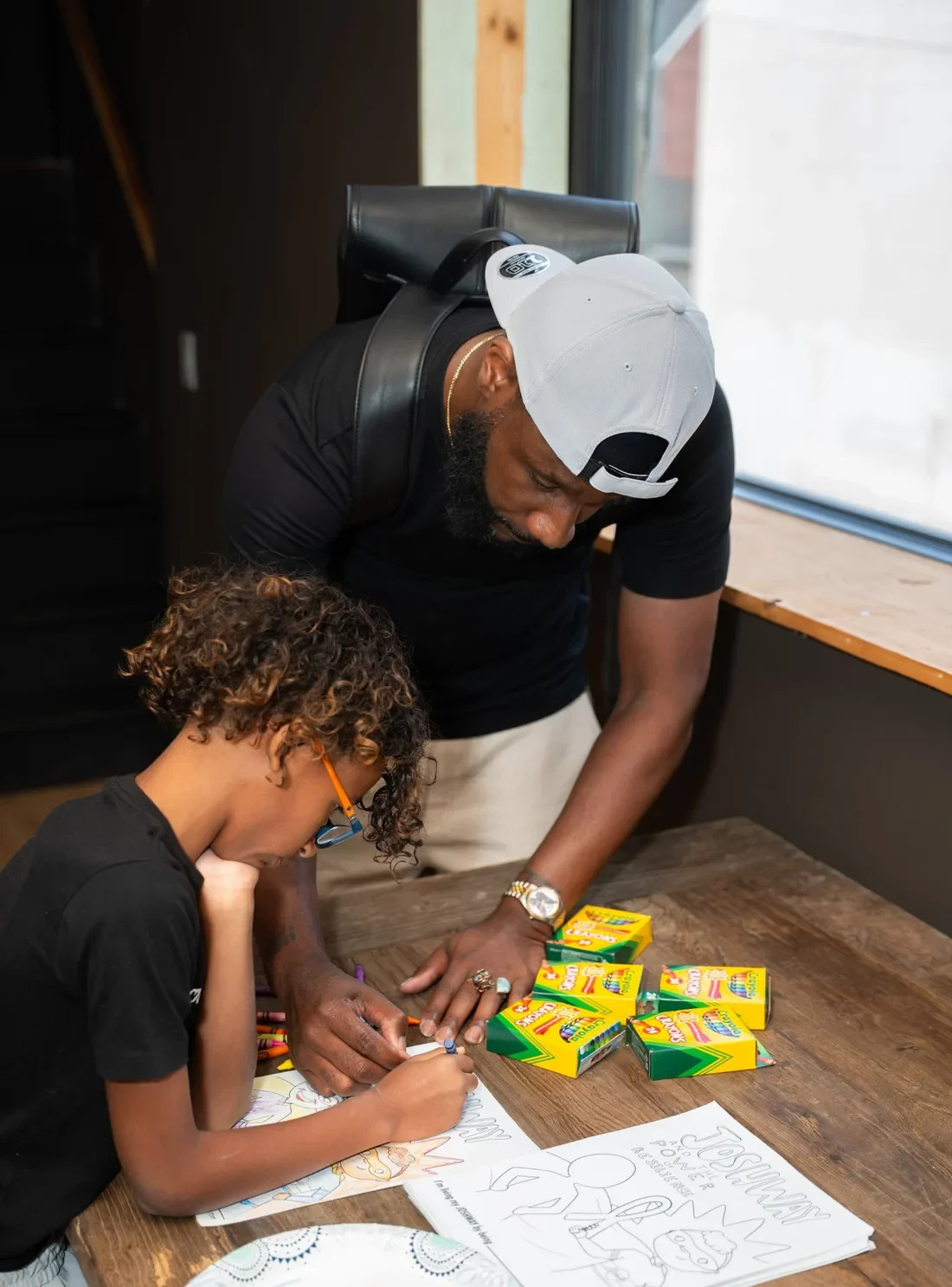 JOSHWAY mentor helping a young student color a Power of Resilience activity page